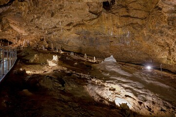 Karst formations inside Punkva Cave with illuminated stalactites and stalagmites, Moravian Karst, Czech Republic.