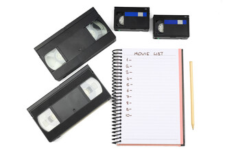 Black VHS video tape cassette with blank label isolated on white background. And empty movie list.