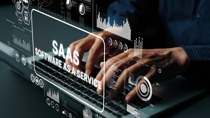 Hands Typing on Keyboard with SaaS Concept Overlays Displaying Software as a Service Graphics and Data Visualizations. Asymptotic smart data analytic.