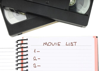 Black VHS video tape cassette with blank label isolated on white background. And empty movie list.