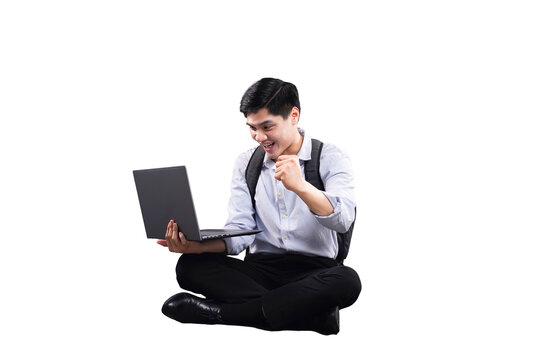 Digital Triumph: A young man seated cross-legged, his eyes alight with delight as he celebrates his accomplishments using a laptop. An ode to the dynamic realm of modern achievement.