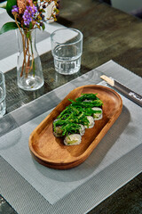 Delightful Sushi Platter with Fresh Ingredients on a Elegant Wooden Base Surrounded by Stylish Dining Setup and Decorative Vases