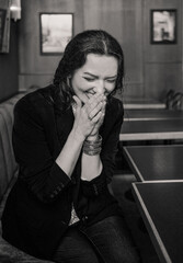 Smiling woman with flowers in a cafe, black and white portrait