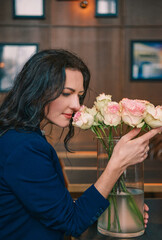 Smiling woman with flowers in a cafe, black and white portrait
