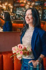 Smiling woman with flowers in a cafe, black and white portrait