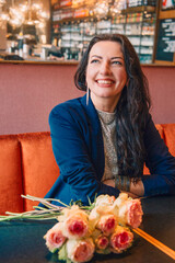 Smiling woman with flowers in a cafe, black and white portrait