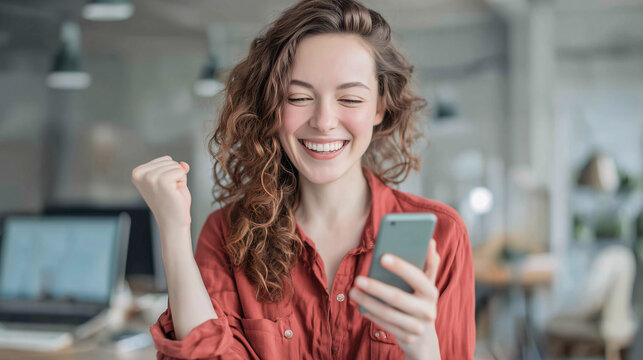 young woman using mobile phone with gesture of joy and celebration