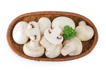 Fresh mushroom champignon in a wicker basket isolated on white background. Top view. Flat lay.