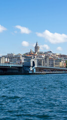 Obraz premium View of city of Istanbul, Galata Tower and Galata Bridge from opposite shore of Bosphorus Strait, Sea of Marmara, Turkey. Vertical image