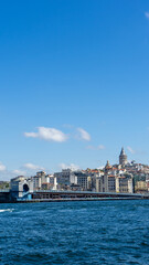 Obraz premium View of city of Istanbul, Galata Tower and Galata Bridge from opposite shore of Bosphorus Strait, Sea of Marmara, Turkey. Vertical image