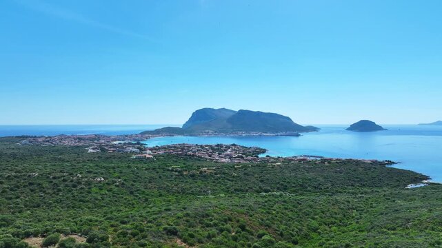Panoramic aerial drone footage captures the stunning natural beauty of Golfo Aranci and the iconic Tavolara island under a clear blue sky