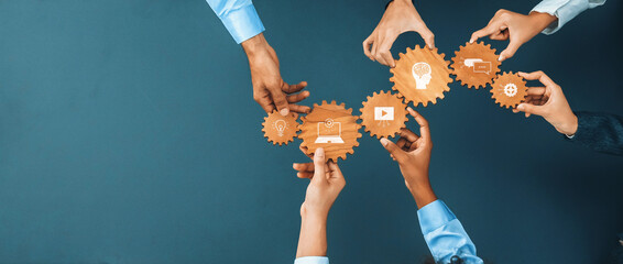 A group of diverse hands holds gears with images representing innovation and technology, showcasing teamwork and collaboration in a modern workspace for enhanced processes. Amity