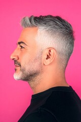 Obraz premium Chic men's high fade haircut - midlife middle eastern man with short hair. A man with timeless elegance and a natural smile. Creative of style for aging men. Pink solid background.