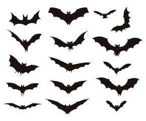 A collection of black bat silhouettes in various flying positions against a white background surface