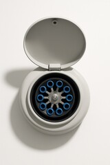 Minimalist top-down view of an open medical centrifuge on a white background