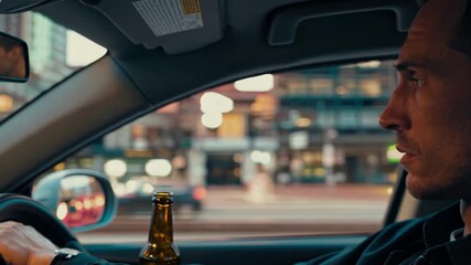 Man driving car at night with beer bottle on dashboard