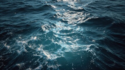 Naklejka premium Deep blue ocean surface showing textured ripples and waves under soft light during a tranquil afternoon, capturing nature's serene beauty and dynamic patterns