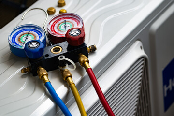 Refrigerant Manifold Gauges Connected to AC Unit