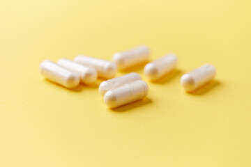 Collagen capsules. Bright paper background. Soft focus. Close up. Copy space.	