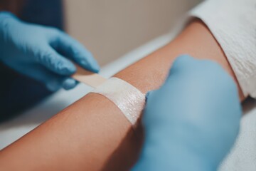 Sugar waxing procedure on female arm with professional care at beauty salon for smooth skin and hair removal