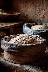 Obraz premium Dough rests in wooden baskets lined with cloth, waiting to rise in a warm kitchen. The textured walls and wooden surfaces create a rustic, inviting atmosphere