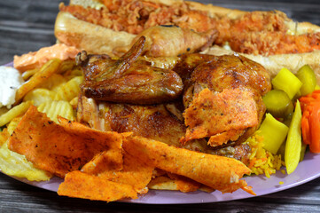 Arabic Syrian cuisine of machine grilled barbecued chicken with colorful Basmati rice, fried potato chips, with garlic sauce Tomeya, pickles, Spicy crispy chicken pieces sandwich, Samosa with cheese