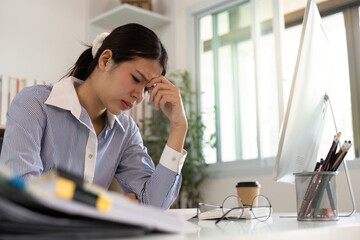 Office Syndrome: Young woman feeling overwhelmed and stressed at her workplace