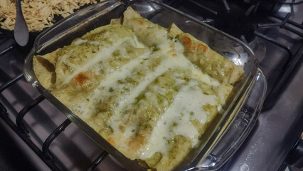 Delicious green chicken enchiladas Suizas with melted cheese, healthy homemade food.