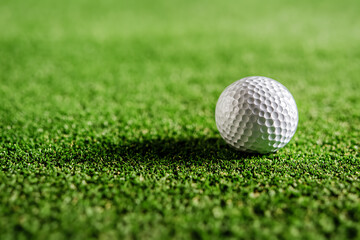 Obraz premium Golf ball resting on bright green grass, focused shot. Awaiting next play, precision sport. Course maintenance.