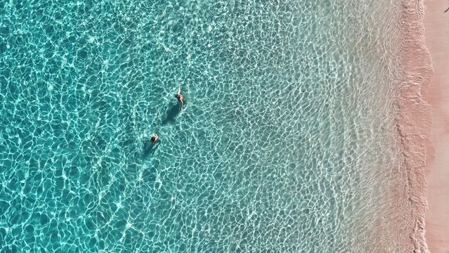 Drone shot of swimmers at pink beach on Pulau Padar in East Nusa Tenggara Komodo Indonesia