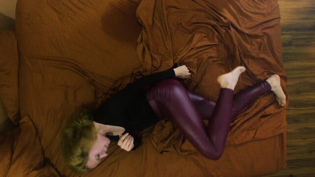 Woman writhes on a bed during an exorcism