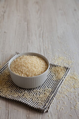 Uncooked White Organic Basmati Rice in a Bowl, side view. Copy space.