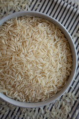 Uncooked White Organic Basmati Rice in a Bowl, top view. Close-up.