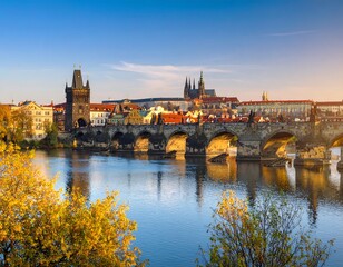 Fototapeta premium Autumnal Prague cityscape panorama. Golden hues bathe Charles Bridge and the Vltava River. City buildings, with rooftops and spires, reflect in the calm water