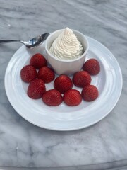 Strawberries with Whipped Cream on a White Plate
