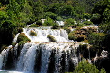 A cascade waterfall among large stones in Krka Park, Croatia, The best big beautiful Croatian waterfalls, mountains and nature.