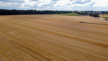 Drone flight over field of freshly harvested grain