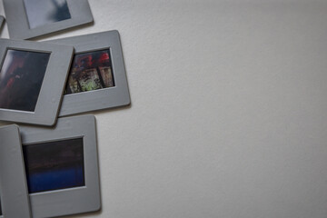 Classic photo slides laying on a white table evoking memories and nostalgia. Empty space for text