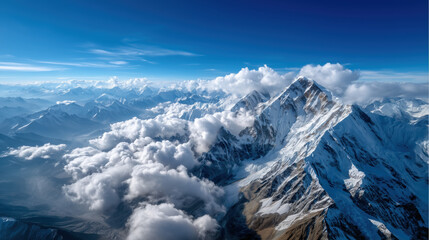 Spectacular aerial view of towering mountains with snow and clouds.