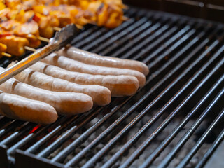 sausages are cooked on the grill over an open fire