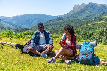 Hikers resting and drinking water in the mountain during summer trekking