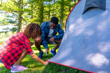 Couple setting up tent in forest camping trip