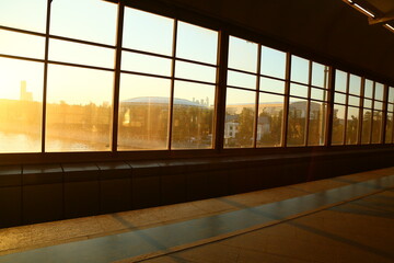 Interior of a modern underground with windows on the city street in sun light. Natural sun ray light colors