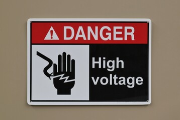 Danger High Voltage safety sign warning notice on wall electrical industrial occupation.