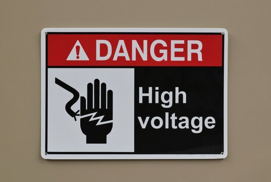 Danger High Voltage safety sign warning notice on wall electrical industrial occupation.