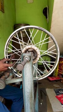Mysuru, Karnataka, India-July 20 2025; A motorcycle wheel rim is being repaired with Jigs and fixtures, workshop, spokes, stainless steel, metal, hub, bearings at a auto garage in Mysore, India.
