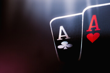 A pair of aces on a black background, close up. 