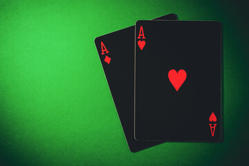 A pair of aces on a green background, close up shot. Ace of hearts and ace of diamonds. Nuts hand a pair of aces to win. Close-up image a pair of aces.