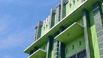 Art Deco Inspired Green Building Against Blue Sky, Unusual Architectural Design of a Modern...