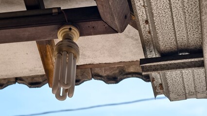 Fluorescent Light Fixture Under Old Metal Roof, Urban Decay: A Close-Up of an Exterior Light and Weathered Roof